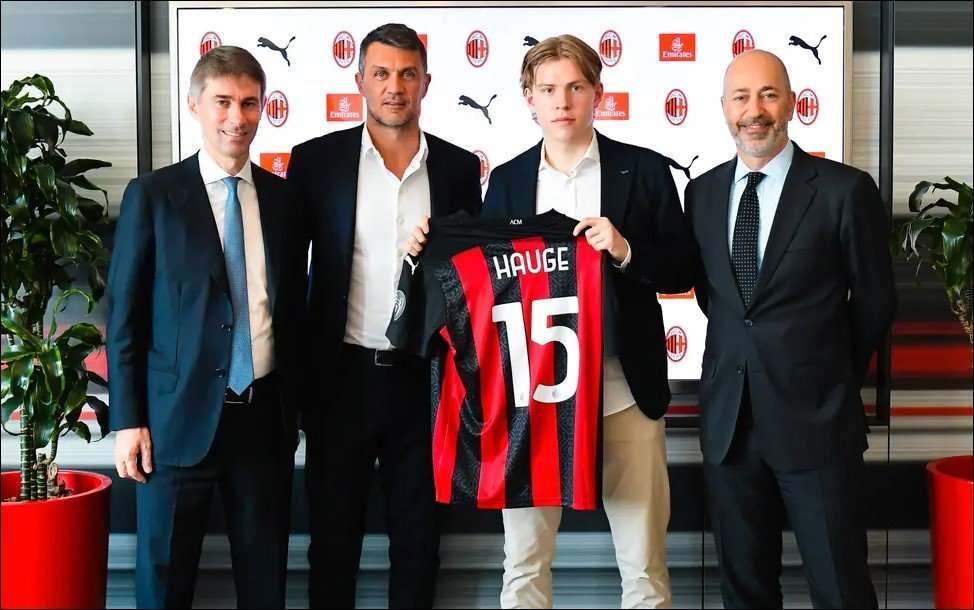 Fire personer holder opp en AC Milan-drakt